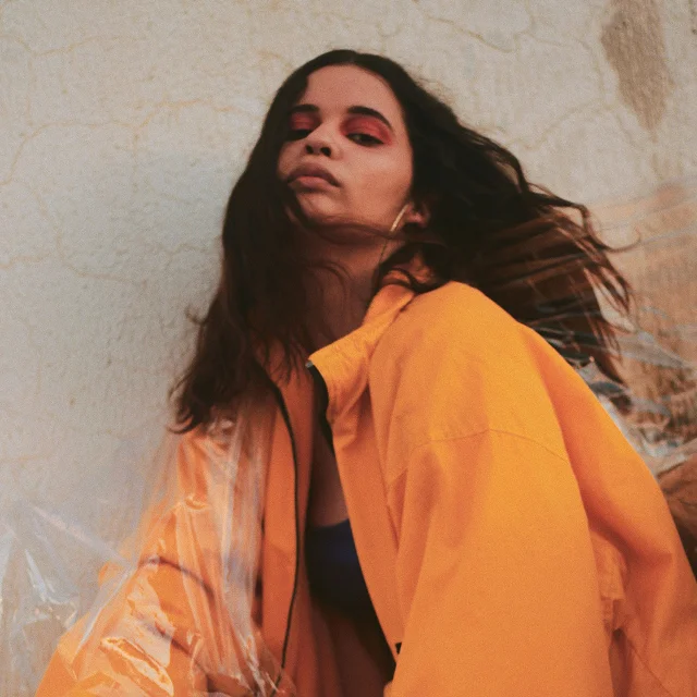 Frau mit einer orangefarbenen Jacke