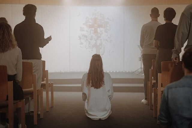 Frau kniend im Gebetsraum